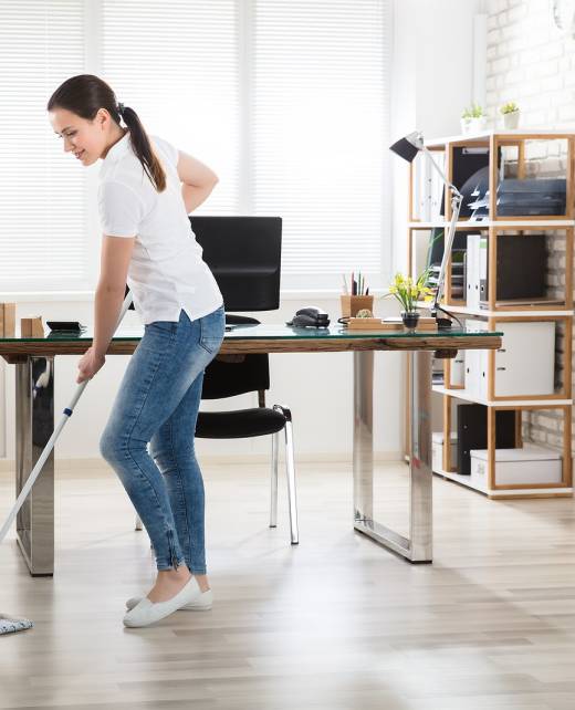 Happy Young Woman Cleaning The Floor With Mop In Modern Office